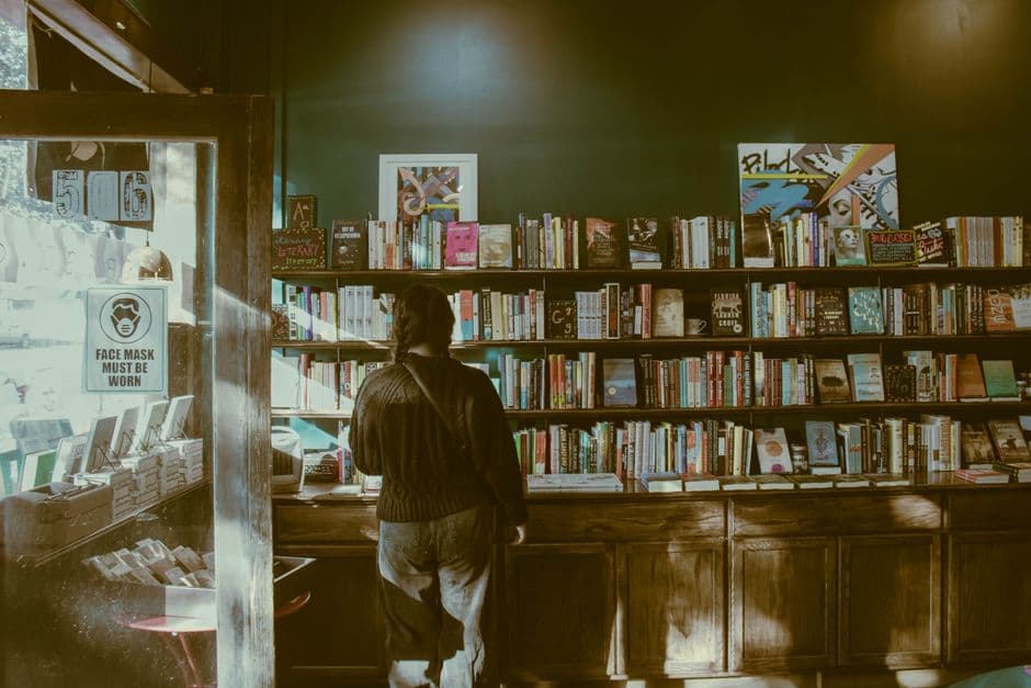 A person browsing shelves in a small bookshop