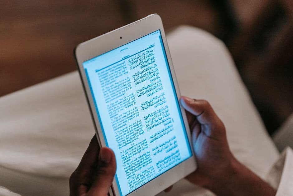 A person reading on a tablet, seen from the side