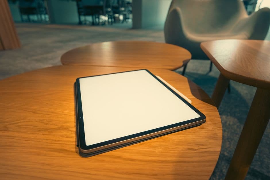 A tablet resting face-up on a wooden table