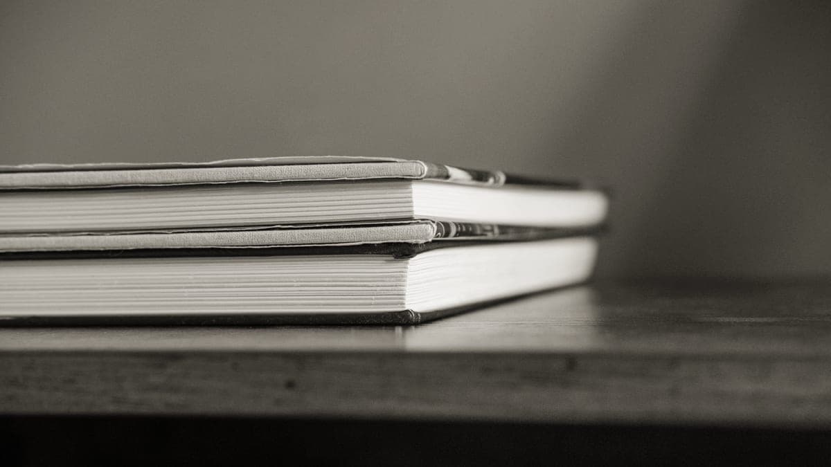 Two stacks of books standing side by side on a desk