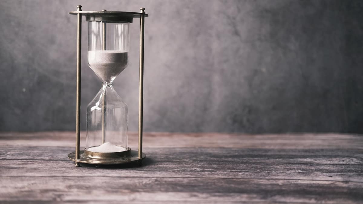 An hourglass standing on a wooden table
