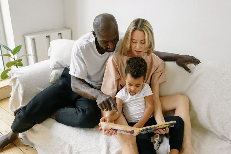 A family reading together on a sofa