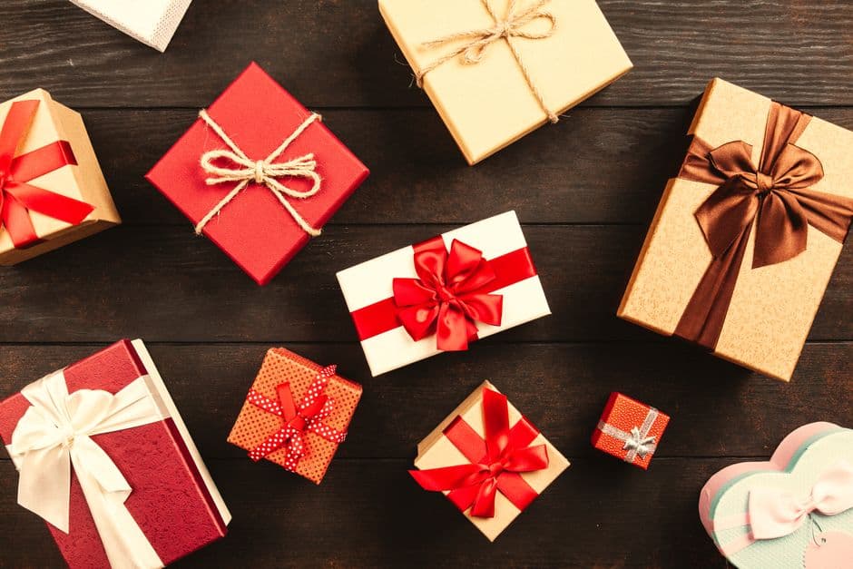Wrapped gifts with ribbons on a wooden table