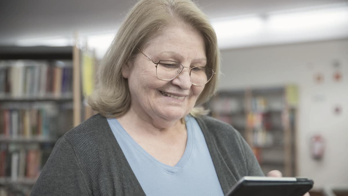 A woman using a tablet in a library