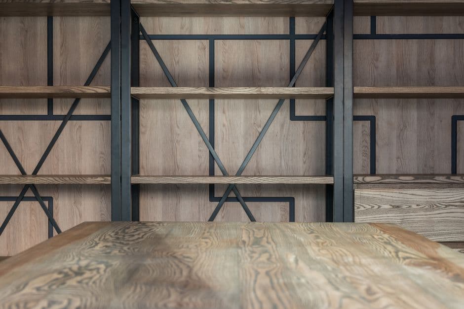 Empty wooden shelves against a pale wall