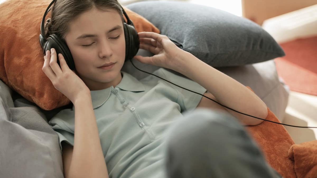 A child wearing headphones listening at home