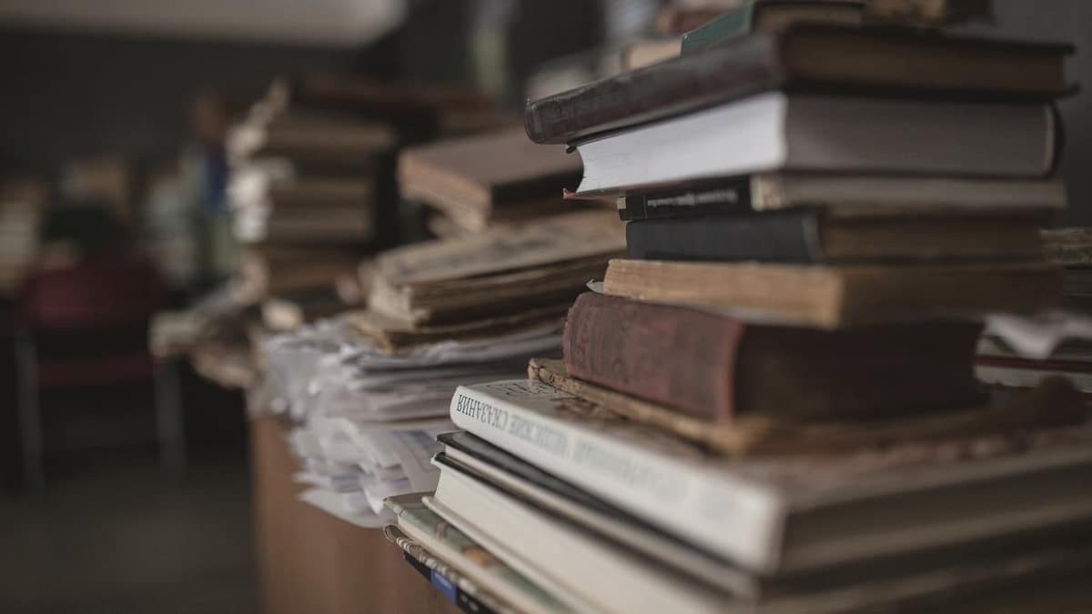 A tall stack of old books on a table