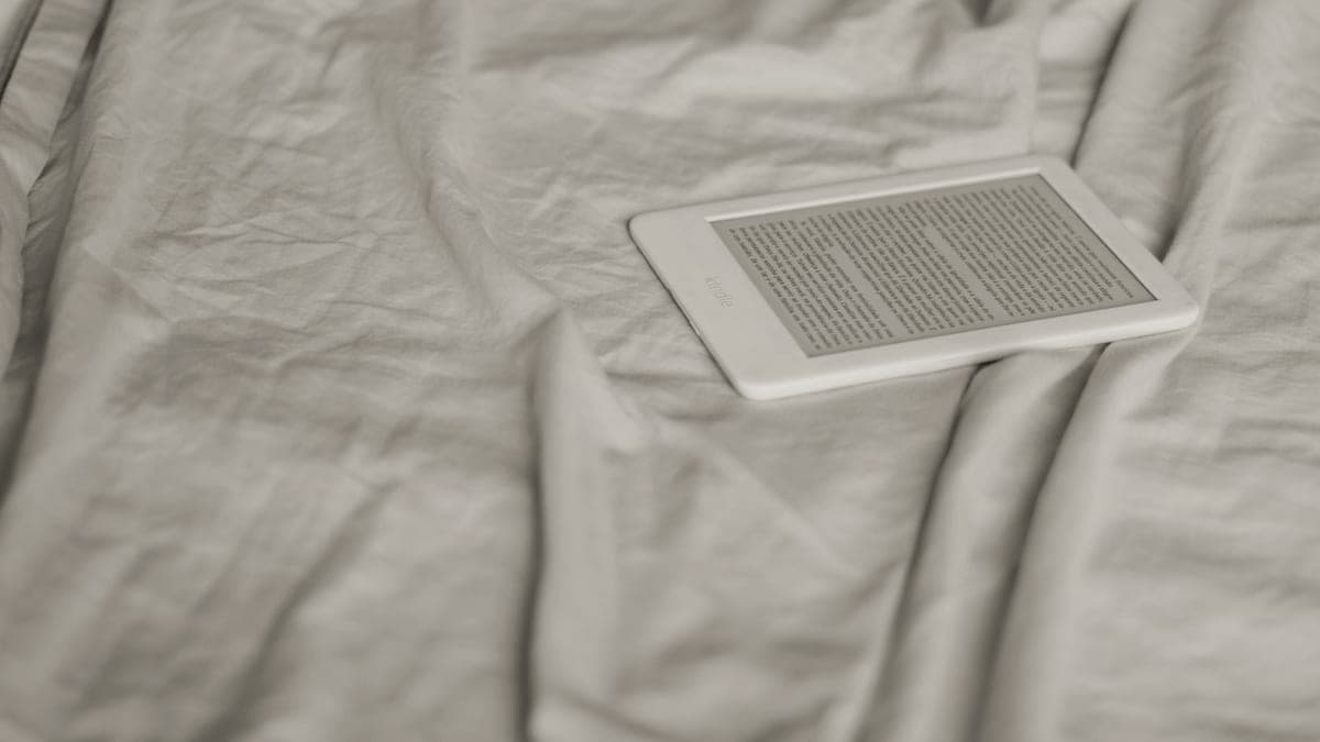 A person reading an ebook on a tablet in low light