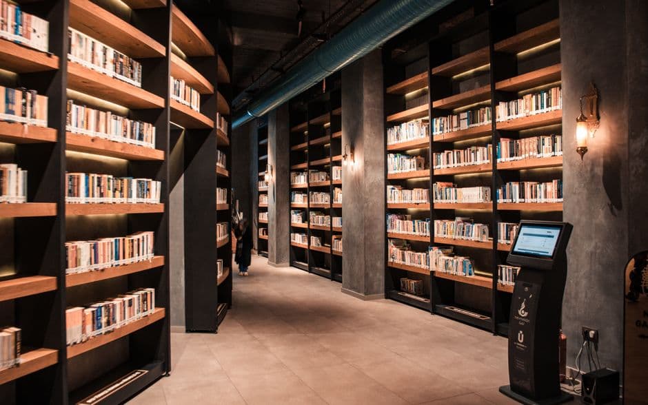 Tall wooden shelves filled with books in a library