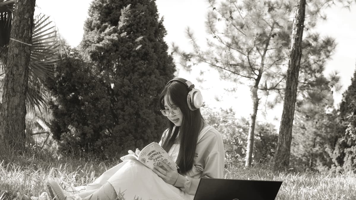 A student working at a laptop with headphones on a desk