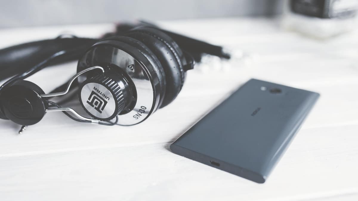 Headphones and a smartphone on a wooden surface